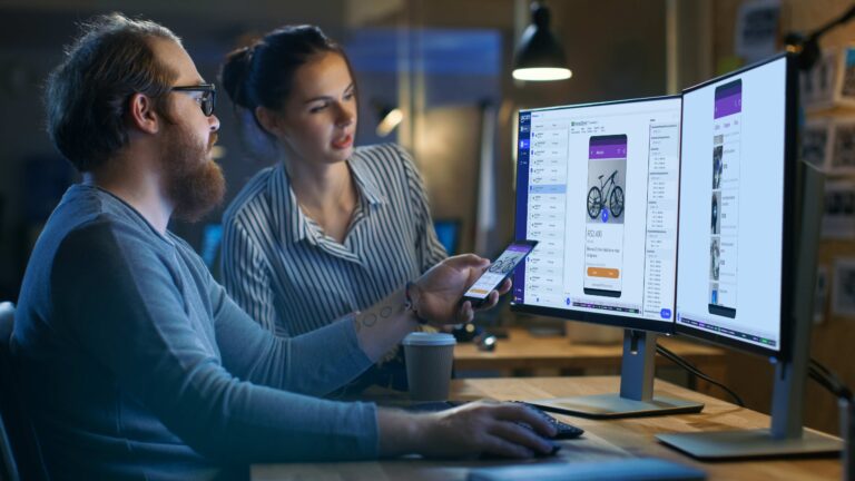 SkyGuru designers reviewing an app on two monitors